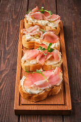 gourmet ham and cream cheese canapés on wooden board - 763119319