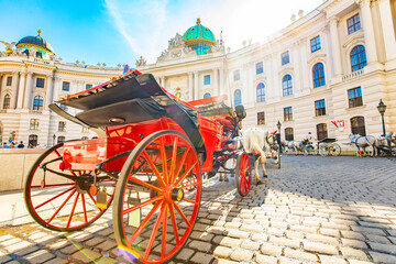 Hofburg palace and horse carriage on sunny Vienna street