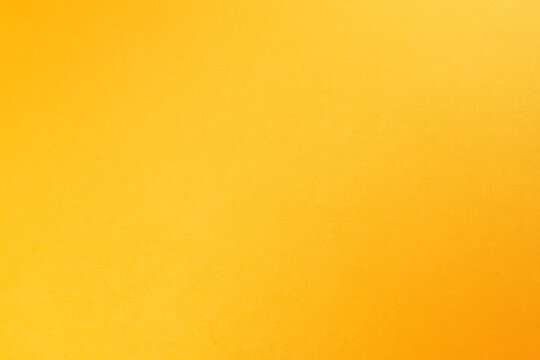 Bright fresh yellow orange tone color paint on environmental friendly cardboard box blank paper texture background with space minimal style joyful concept