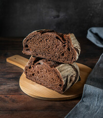 Homemade sourdough bread. Fresh Sourdough bread cut in half,  on a black background. 