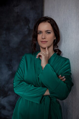 Beutiful woman in green pajamas against the wall