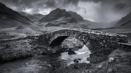 an ancient drystone bridge carrying an early road through Glen Coe in the Scottish Highlands. Photographed in monochrome. - obrazy, fototapety, plakaty