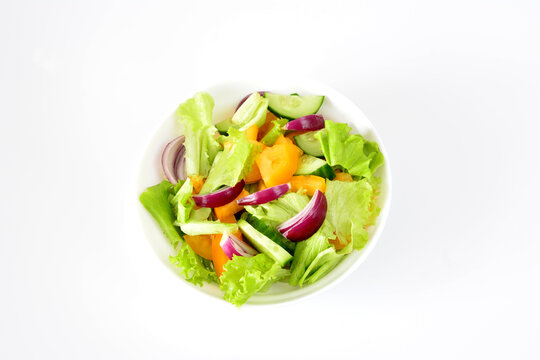 a bowl of salad with yellow tomatoes, cucumber and red oinion 