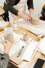 Fototapeta na wymiar Ceramic Crafting: Women Molding Clay Vases