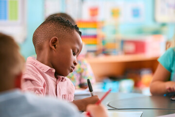 Male Primary Or Elementary School Student At Desk In Classroom - 763135757
