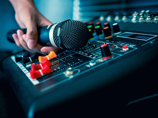 Hand Sound engineer  holding microphone on sound mixer in live broadcasting studio producer for...