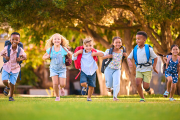 Multi-Cultural Primary Or Elementary School Students With Backpacks Running Outdoors At End Of Day - 763136302