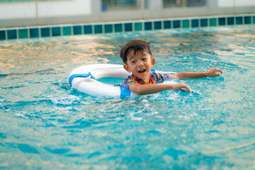 Little kindergarten boy enjoying swim in condominium swimming pool