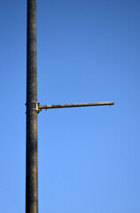 Old Steel Pole and Bracket seen against Blue Sky