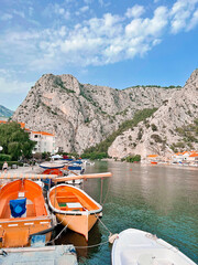 boat on the river bank and against the backdrop of mountains in the city of Omis Croatia