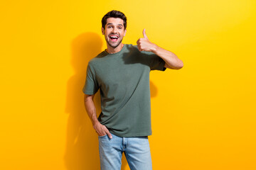 Portrait of funny ecstatic guy with stubble wear stylish t-shirt show thumb up nice job arm in...