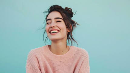 Young woman laughing at a good joke on pastel blue background - obrazy, fototapety, plakaty