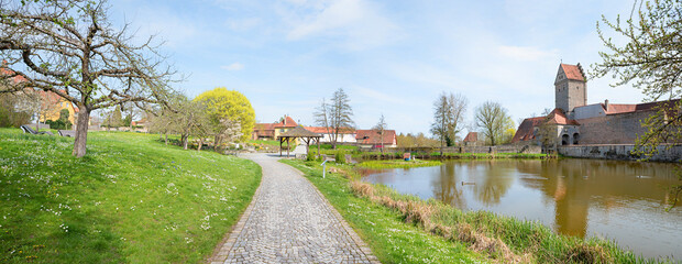 water moat around historical town Dinkelsbuhl with tower, park landscape in spring