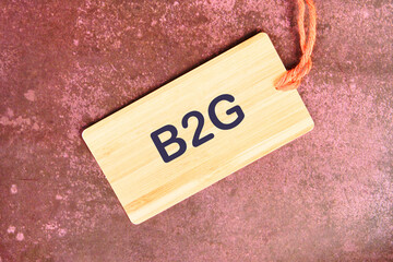 Business concept. The letters B2G on a card with a rope on an abstract background