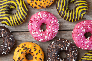 Set of colorful donuts on wooden background