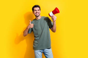Portrait of satisfied guy with stubble wear stylish t-shirt hold loudspeaker showing thumb up...