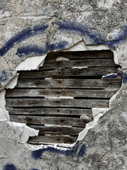 Foto astratta di un buco sul muro, riparato con delle tavole di legno