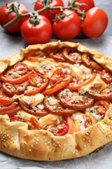 Tasty galette with tomato and cheese (Caprese galette) on table, closeup
