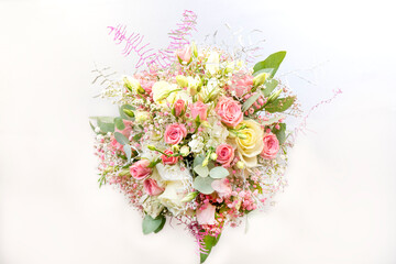 Beautiful delicate bouquet of stabilized flowers, roses, dried flowers, twigs of leaves on a light background is isolated, close. bridal bouquet, gift bouquet