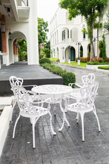 Classic white steel chair and table in the garden,empty white vintage chairs in the garden,decoration english garden concept.