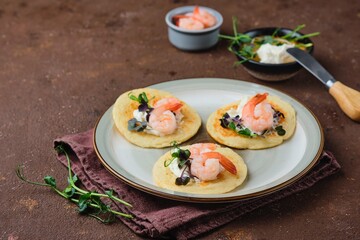 Pancakes with cream cheese, microseneous and shrimp on a ceramic plate on a brown concrete background. Pancakes recipes, snacks. International Pancake Day.