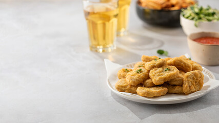 There is a plate of crispy chicken nuggets on the table. Fast food, fast food restaurant. Copy space