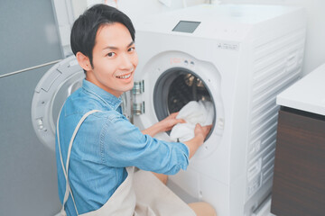 洗濯をするエプロン姿の男性