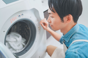 洗濯をするエプロン姿の男性