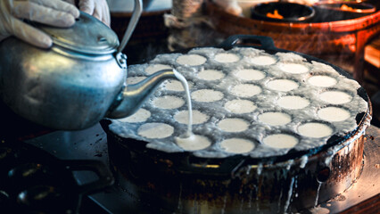 "Khanom khrok" asian food coconut-rice pancakes are one of the ancient Thai desserts. They are prepared by mixing rice flour, sugar, and coconut milk to form a dough
