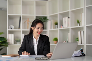 Fototapeta premium Young business woman asian or employee accounting bookkeeping documents checking financial data or marketing report working in office with laptop. Paperwork management