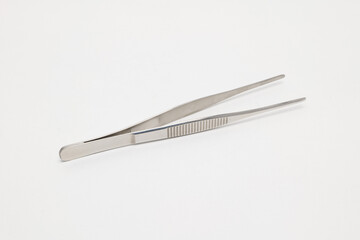 Stainless steel tweezers on a white background.