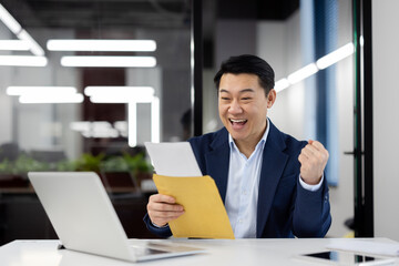 Happy businessman celebrating success with a letter