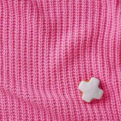 White Gingerbread Cross on Warp Knitted Sweater Fabric. Top View. Valentine's Day Design