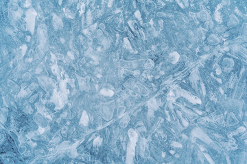 Close-up photo of transparent light blue ice of Baikal lake with white frost ornament. Great backdrop for your design with copy space. Top view.