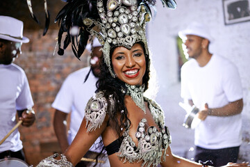 Portrait, happy woman and dancing at carnival with band for performance, party or celebration. Face, samba and Brazilian person at music festival in feather costume, makeup and smile at concert event