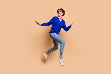 Fototapeta na wymiar Full length profile portrait of cheerful pretty person jump run look back empty space ad isolated on beige color background