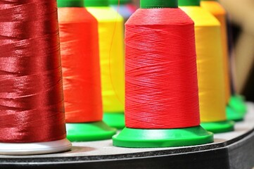 close up view of colorful spools of thread for fabrics