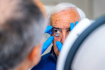 Ophthalmologist placing an eye opener to a senior man