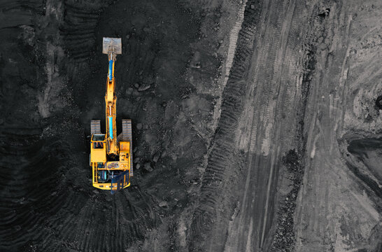 Coal mining in an open pit. Mining excavator loads coal in haul truck in quarry. Excavator digging in an open pit coal mine. Tipper truck hauling minerals from open-pit. Heavy machinery in opencast.