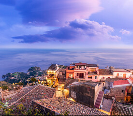 Obraz premium amazing evening view from mountain town to beautiful italian town with roofs and biuldings and scenic water of a sea gulf with amazing cloudy sky on background