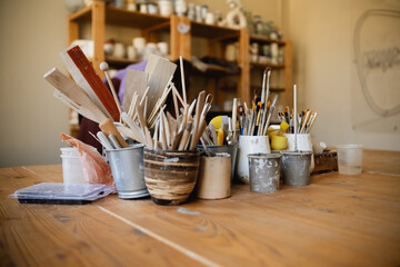Table with brushes and tools in an art workshop. Background.