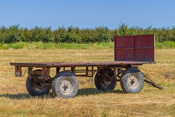 Empty Flatbed Agriculture Trailer at Field Sunny Summer Day