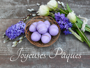 Carte de vœux Joyeuses Pâques : Nid avec œufs de Pâques violets, fleurs et inscription...