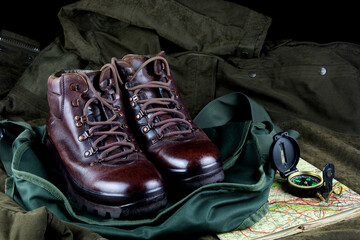 Old hiking Boots with Compass and Old Map on an Outdoor Bag and Field Coat - 763200369