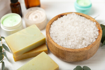 Beautiful spa composition on a wooden background with eucalyptus leaves. Beauty and fashion spa concept with body cream, scrub, mask, essential oil and sea salt.Cosmetic product. Copy space.