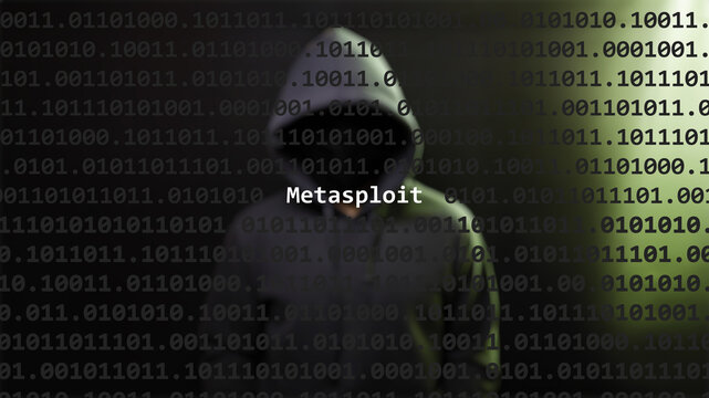 Cyber attack metasploit text in foreground screen, anonymous hacker hidden with hoodie in the blurred background. Vulnerability text in binary system code on editor program.