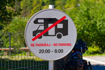 Traffic sign no parking allowed for motor homes between 6:00 and 20:00 at Predjama castle on a sunny summer day. Photo taken August 11th, 2023, Predjama, Slovenia.