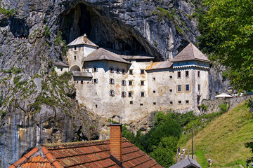 Beautiful impressive medieval castle with cave in the background at Slovenian village of Predjama on a sunny summer day. Photo taken August 11th, 2023, Predjama, Slovenia.