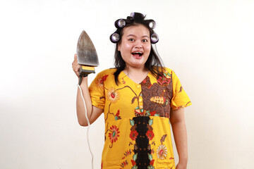 Wow excited asian housekeeper woman standing while holding an iron