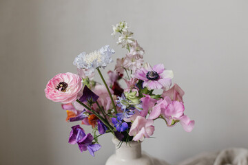 Summer flowers in vase, rustic still life. Beautiful colorful anemone, ranunculus, lathyrus, scabiosa close up. Floral moody wallpaper. Space for text